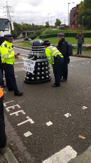 Police try to stop and search a Dalek. #StopDSEI
